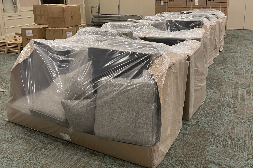 Neatly packaged furniture in a commercial space being moved.